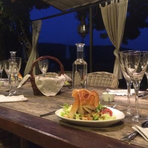 Table élégamment dressée en extérieur, avec des plats raffinés sous un ciel étoilé.