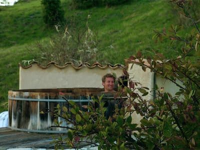 Hébergement insolite en Provence-Alpes-Côte dAzur avec un jacuzzi en bois entouré de verdure.