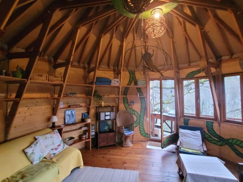 Cabane en bois avec un intérieur chaleureux et des murs décorés de motifs naturels.