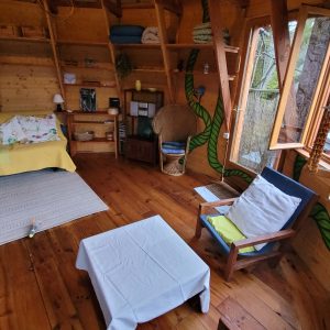 Cabane en bois à Limousin, avec un intérieur chaleureux et de grandes fenêtres.