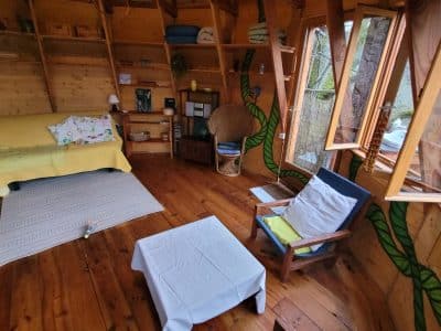 Cabane en bois à Limousin, avec un intérieur chaleureux et de grandes fenêtres.