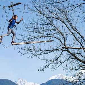 Hébergement insolite en cabane dans les arbres, avec vue sur les montagnes enneigées.