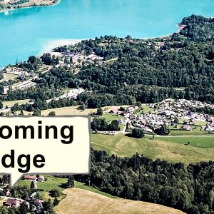Lodge Wyoming au bord dun lac, entouré de verdure et de paysages montagneux.