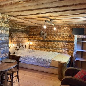 Cabane en bois dans les montagnes, avec un lit douillet et des murs rustiques.