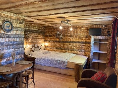 Cabane en bois dans les montagnes, avec un lit douillet et des murs rustiques.