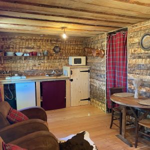 Cabane en bois cosy avec cuisine équipée et décoration rustique en Auvergne-Rhône-Alpes.
