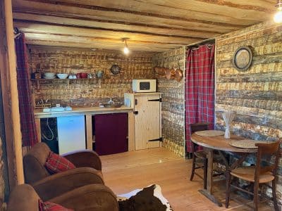 Cabane en bois cosy avec cuisine équipée et décoration rustique en Auvergne-Rhône-Alpes.