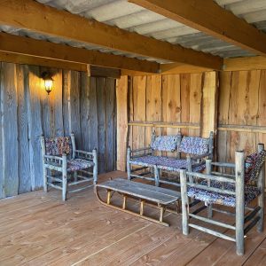 Hébergement insolite en Auvergne-Rhône-Alpes, salon en bois avec fauteuils colorés.