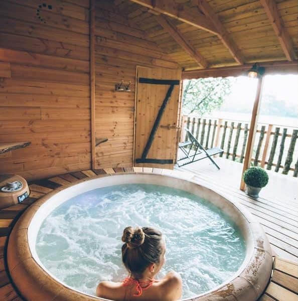 Chalet avec jacuzzi intérieur, ambiance bois et vue sur la nature.