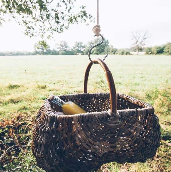 Panier suspendu en osier, parfait pour un pique-nique en pleine nature.