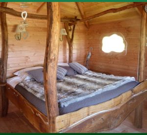 Cabane en bois avec un lit douillet et des décorations en cœur.