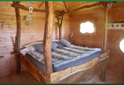 Cabane en bois avec un lit douillet et des décorations en cœur.