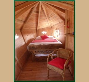 Cabane en bois avec un lit douillet et une décoration chaleureuse.