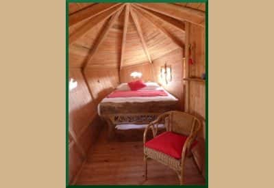 Cabane en bois avec un lit douillet et une décoration chaleureuse.