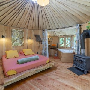 Yourte en bois au Languedoc-Roussillon, avec lit douillet et décor naturel.