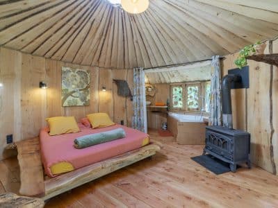 Yourte en bois au Languedoc-Roussillon, avec lit douillet et décor naturel.
