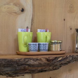 Hébergement insolite en Languedoc-Roussillon avec mugs colorés sur une étagère en bois.