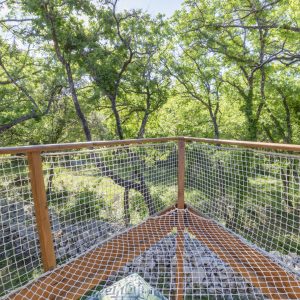 Cabane perchée dans les arbres, vue imprenable sur la forêt verdoyante.