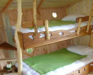 Cabane en bois avec lits superposés, décorée de touches naturelles et chaleureuses.