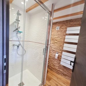 Salle de bain moderne dun hébergement insolite en Bourgogne-Franche-Comté, avec douche vitrée.