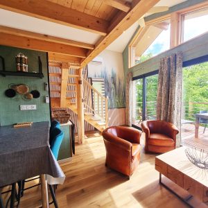 Hébergement insolite en Bourgogne-Franche-Comté, avec un intérieur en bois et de grandes fenêtres.