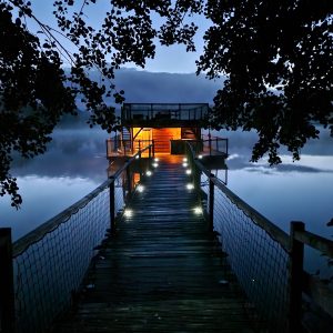 Cabane flottante en Auvergne-Rhône-Alpes, éclairage chaleureux au bord de leau.