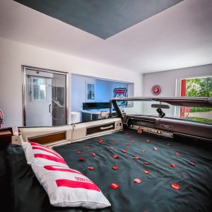 Hébergement insolite en voiture vintage, lit décoré de pétales de rose.