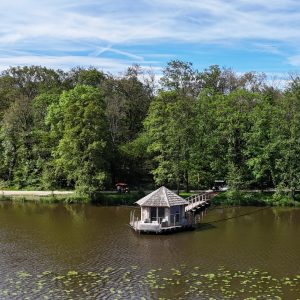 Cabane flottante au bord dun lac, entourée de verdure luxuriante en Auvergne-Rhône-Alpes.