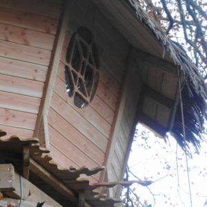 Cabane perchée en bois en Bretagne, avec une fenêtre en forme de tortue.