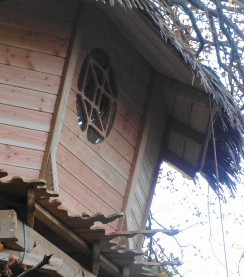 Cabane perchée en bois en Bretagne, avec une fenêtre en forme de tortue.