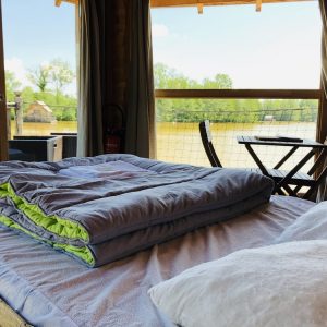 Cabane flottante en Auvergne-Rhône-Alpes, vue sur la rivière depuis la chambre.