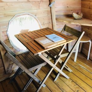 Cabane perchée en Auvergne-Rhône-Alpes avec table en bois et vue arrondie.
