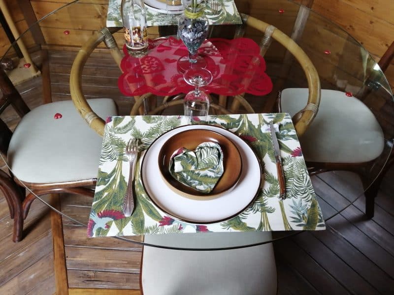 Table élégante dans un chalet en bois, décorée avec des assiettes et des serviettes fleuries.
