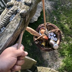 Cabane perchée en Auvergne-Rhône-Alpes, panier suspendu rempli de boissons rafraîchissantes.