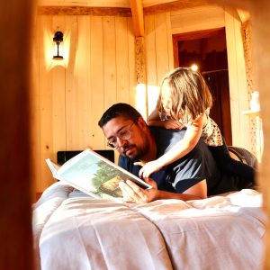 Hébergement insolite en bois en Auvergne-Rhône-Alpes, père et fille lisent ensemble.