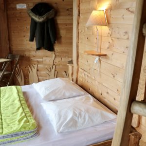 Chalet en bois chaleureux avec lit confortable et décoration naturelle.