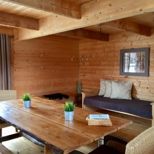 Chalet en bois chaleureux avec table en bois massif et décoration naturelle.