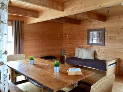 Chalet en bois chaleureux avec table en bois massif et décoration naturelle.