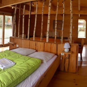 Chalet en bois chaleureux avec lits superposés et vue sur la nature environnante.