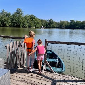 Hébergement insolite en Auvergne-Rhône-Alpes, vue sur un lac depuis une terrasse en bois.