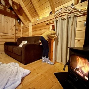 Cabane en bois avec un coin salon chaleureux et un poêle à bois accueillant.