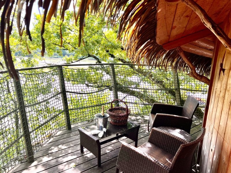 Cabane perchée en Auvergne-Rhône-Alpes avec terrasse en bois et vue sur la nature.