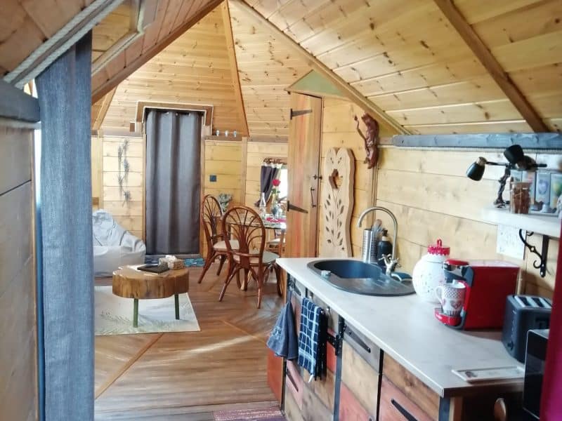 Chalet en bois chaleureux avec cuisine ouverte et décoration rustique.