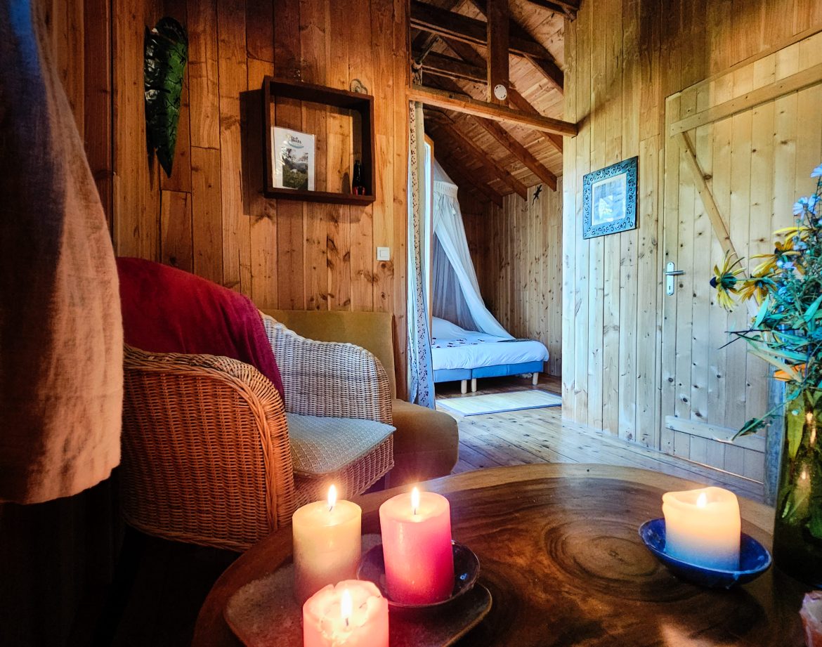 Hébergement insolite en bois à Limousin, avec bougies colorées et ambiance chaleureuse.
