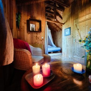 Hébergement insolite en bois à Limousin, avec bougies colorées et ambiance chaleureuse.