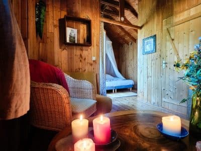 Hébergement insolite en bois à Limousin, avec bougies colorées et ambiance chaleureuse.