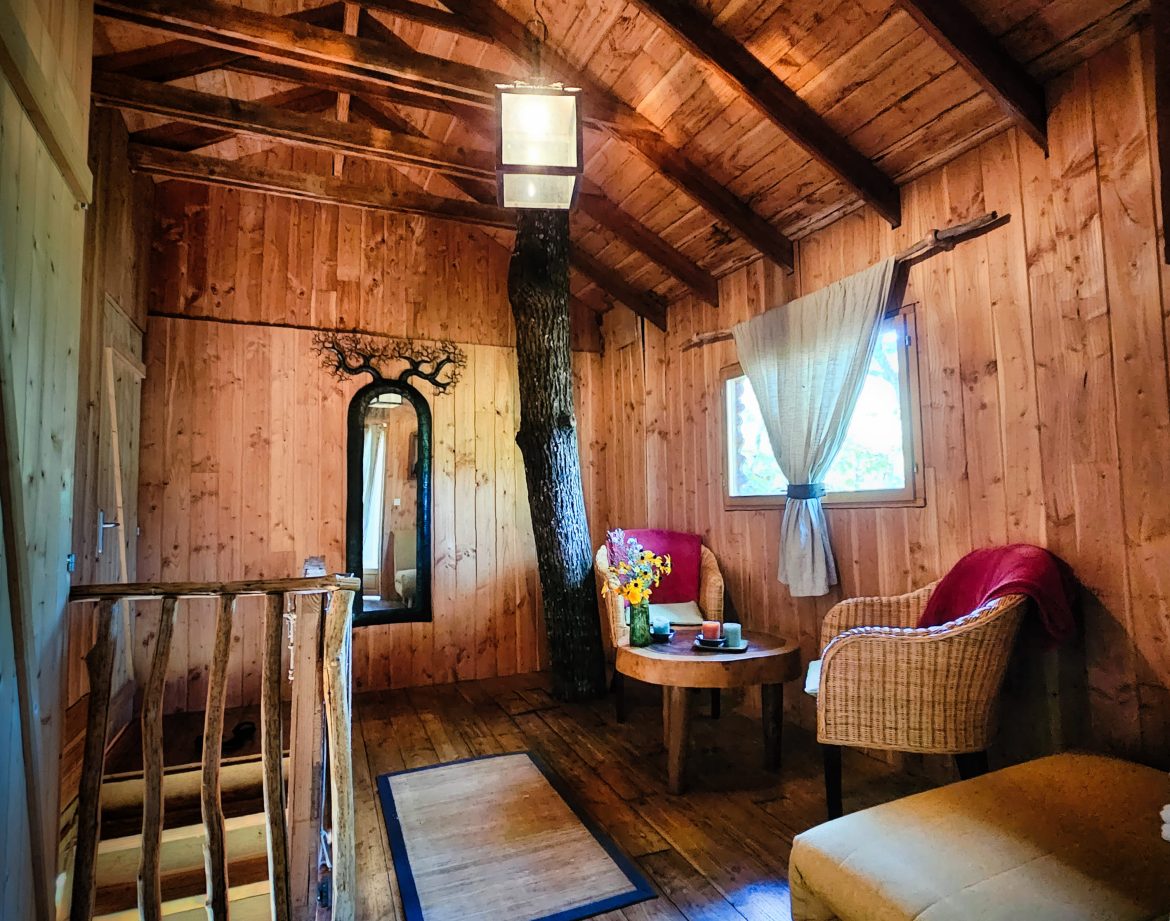 Cabane en bois au Limousin, intérieur chaleureux avec poutres apparentes et mobilier cosy.