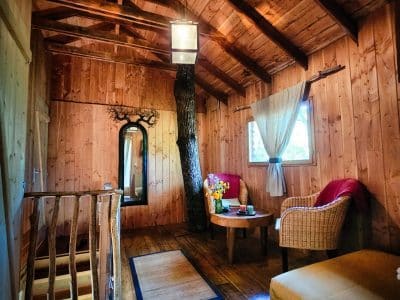 Cabane en bois au Limousin, intérieur chaleureux avec poutres apparentes et mobilier cosy.