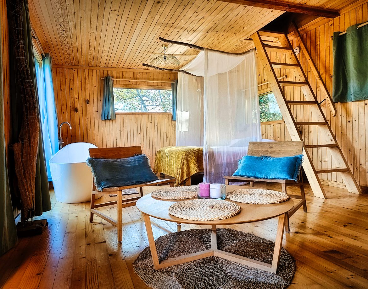 Hébergement insolite en bois à Limousin, avec baignoire sur pieds et coin salon cosy.