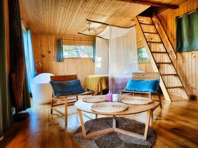 Hébergement insolite en bois à Limousin, avec baignoire sur pieds et coin salon cosy.